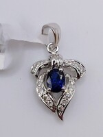 18kt White Gold ~.25ct Oval Blue Sapphire w/ .20tcw Diamond Ribbon Style Pendant